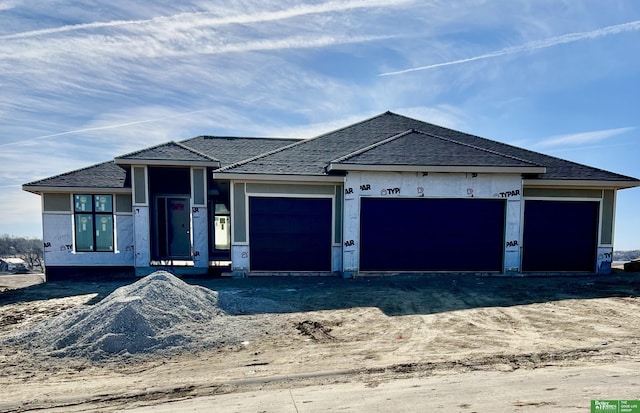 unfinished property featuring driveway and an attached garage