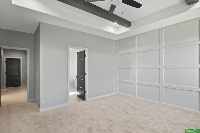 unfurnished bedroom with a decorative wall, beamed ceiling, and carpet flooring