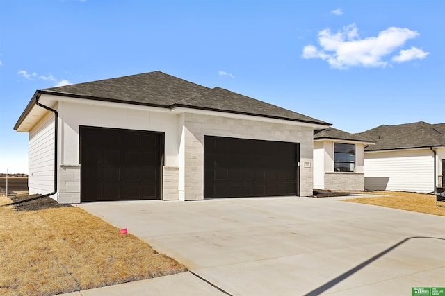 view of front of house featuring stone siding, concrete driveway, roof with shingles, and an attached garage