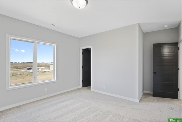 unfurnished bedroom featuring baseboards and light colored carpet