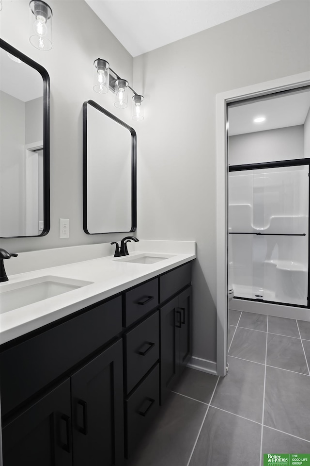 bathroom with double vanity, a shower with shower door, a sink, and toilet