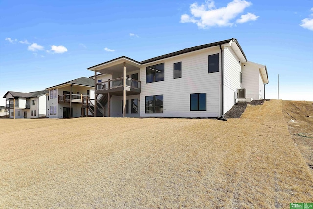 back of property with central AC and a balcony