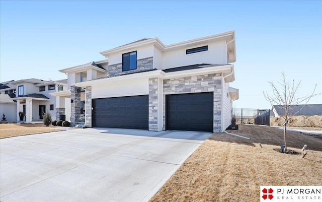 view of front of home with a garage, stone siding, fence, and concrete driveway