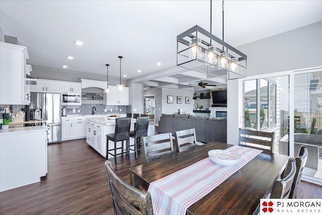 dining space featuring recessed lighting, ceiling fan, dark wood finished floors, and a stone fireplace