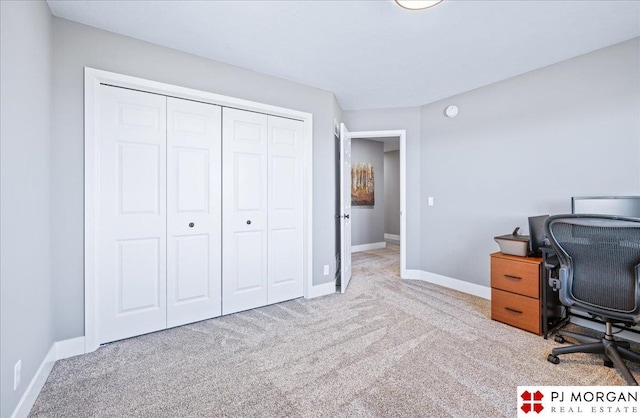 carpeted office space featuring baseboards