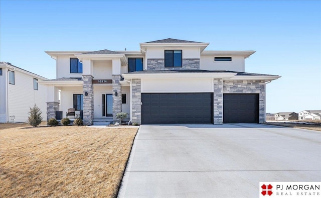 prairie-style house with a porch, an attached garage, concrete driveway, stone siding, and a front yard