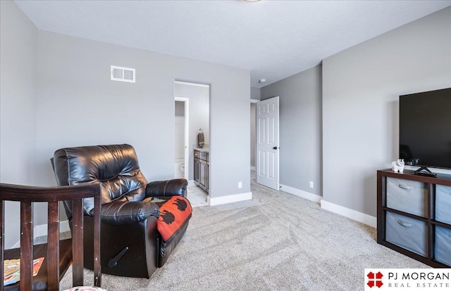 sitting room featuring carpet floors, visible vents, and baseboards