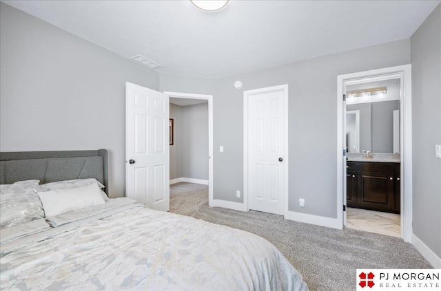 bedroom featuring connected bathroom, carpet flooring, visible vents, and baseboards