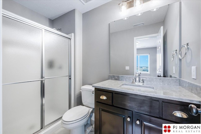 bathroom with toilet, a stall shower, visible vents, and vanity