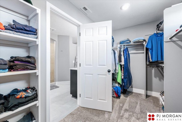 walk in closet with carpet floors and visible vents