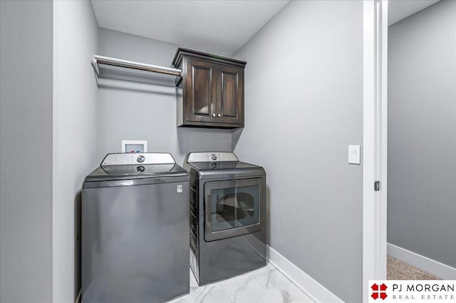 laundry area with marble finish floor, washing machine and dryer, cabinet space, and baseboards