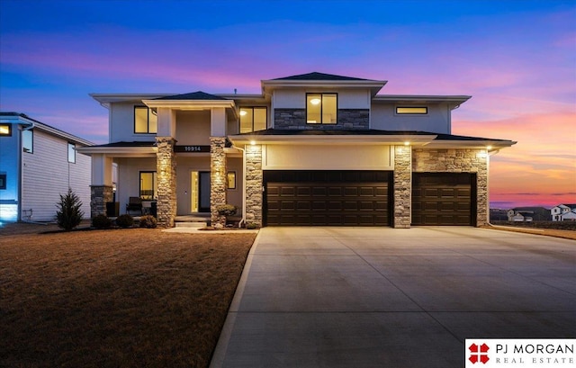 prairie-style home with stucco siding, concrete driveway, covered porch, an attached garage, and stone siding