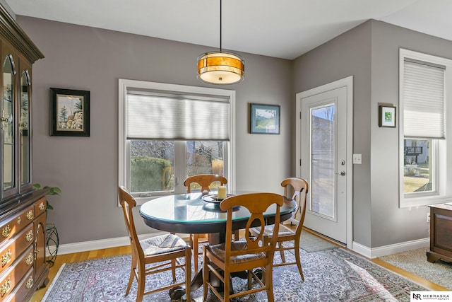 dining area with light wood finished floors and baseboards