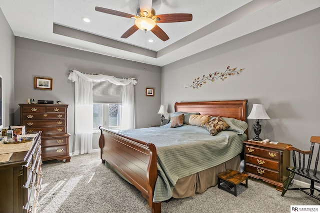 carpeted bedroom featuring a tray ceiling, recessed lighting, baseboards, and ceiling fan