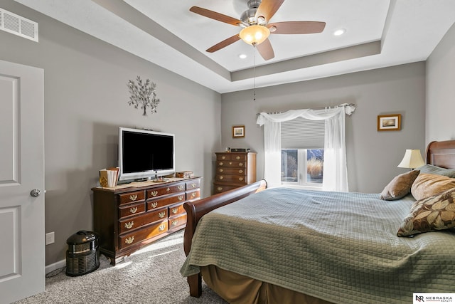 carpeted bedroom featuring visible vents, baseboards, ceiling fan, recessed lighting, and a raised ceiling