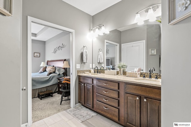 ensuite bathroom featuring ensuite bath, double vanity, and a sink