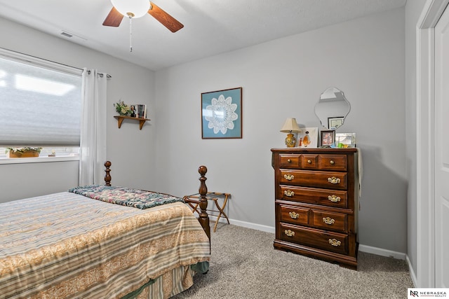 carpeted bedroom with visible vents, ceiling fan, and baseboards