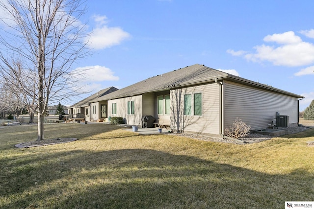 rear view of house featuring a yard and central AC unit