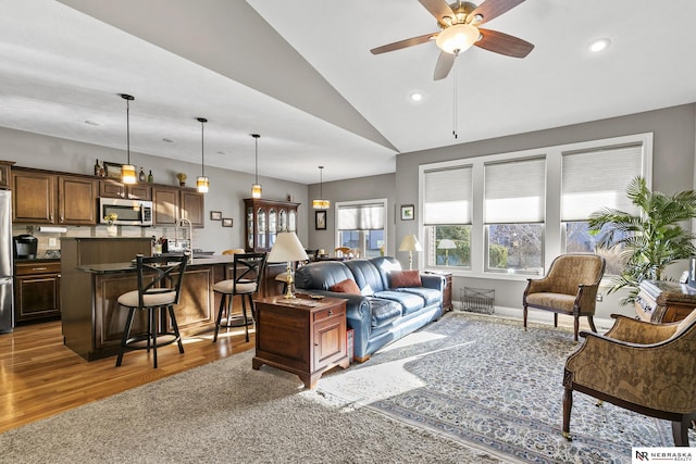 living room with wood finished floors, recessed lighting, baseboards, ceiling fan, and vaulted ceiling