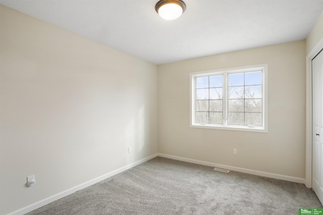 carpeted empty room with baseboards