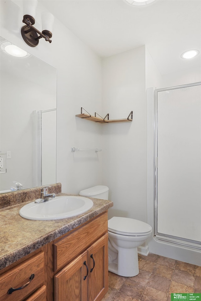 full bathroom with toilet, a stall shower, and vanity