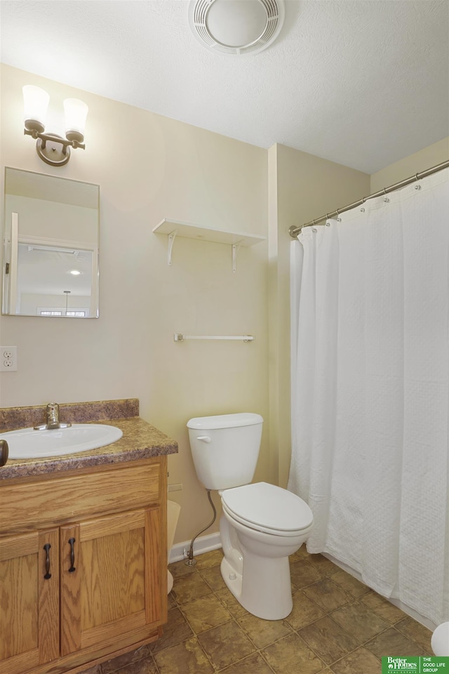 bathroom featuring a textured ceiling, toilet, visible vents, vanity, and baseboards