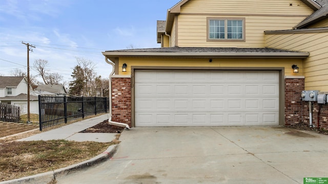 garage featuring fence and driveway