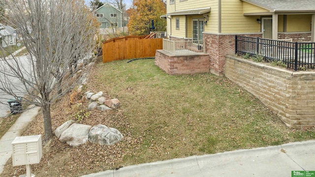 view of yard featuring fence and mail area