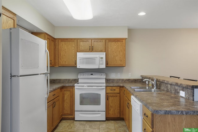 kitchen featuring white appliances, dark countertops, and a sink