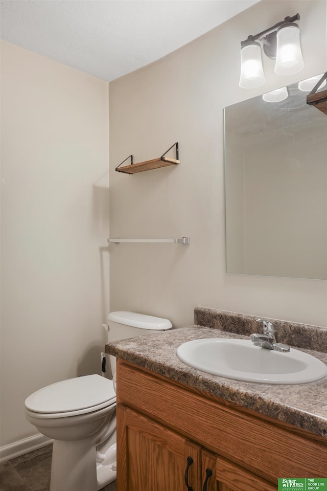 bathroom featuring toilet, tile patterned floors, and vanity