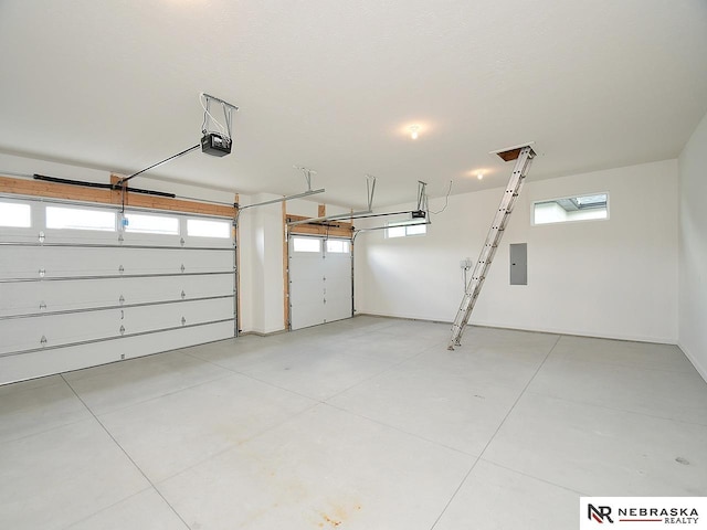 garage with a garage door opener and electric panel