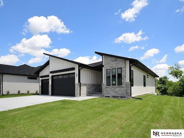 view of front of property featuring an attached garage, stone siding, driveway, and a front yard