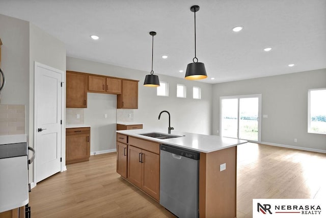 kitchen featuring brown cabinets, light wood-style flooring, decorative backsplash, a sink, and dishwasher