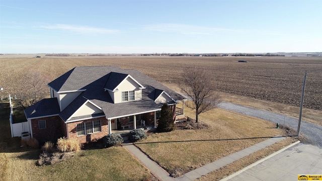 view of front of house with a front yard, a porch, and a rural view