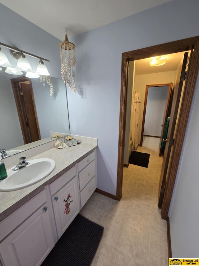 bathroom with tile patterned floors, vanity, and baseboards