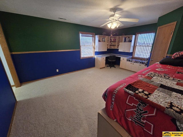 unfurnished bedroom with carpet floors, multiple windows, a ceiling fan, and baseboards