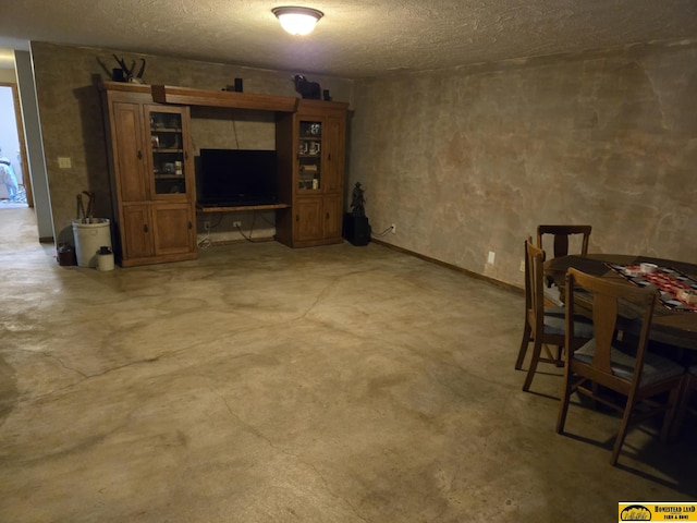 living area featuring concrete flooring and a textured ceiling