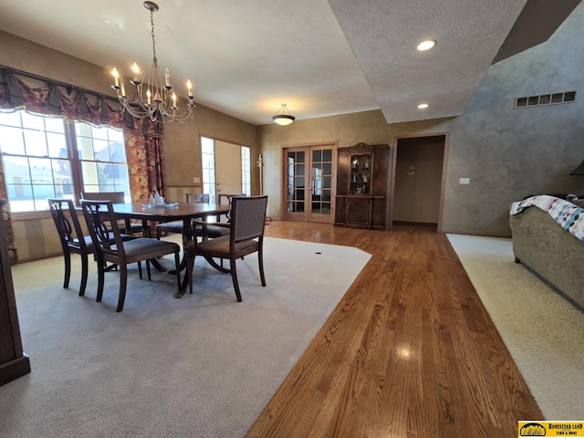 dining room featuring french doors, recessed lighting, visible vents, an inviting chandelier, and wood finished floors