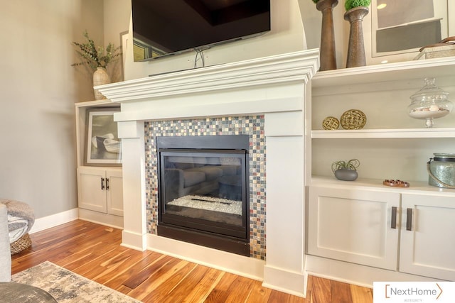 interior details featuring a fireplace, baseboards, and wood finished floors