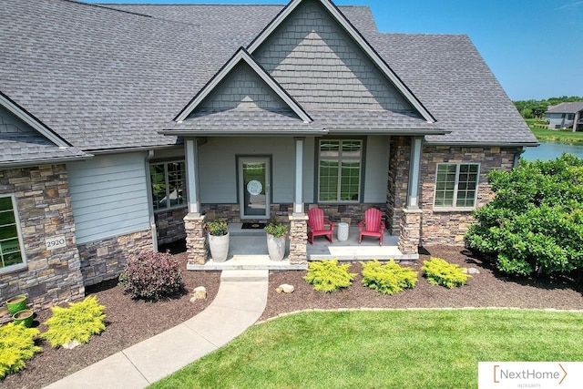 craftsman inspired home with stone siding, covered porch, and a shingled roof