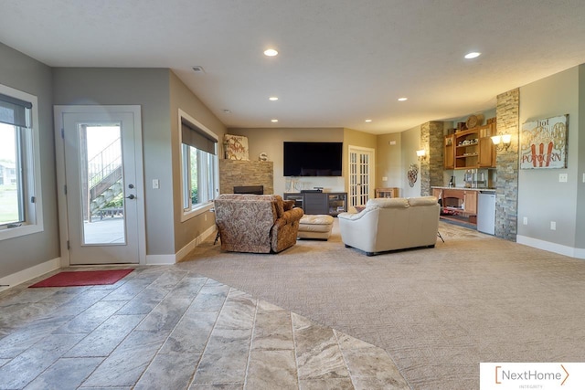 carpeted living room with baseboards, a fireplace, and recessed lighting