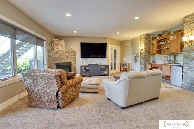 living area featuring light carpet, a fireplace, baseboards, and recessed lighting