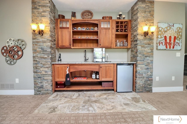 bar with freestanding refrigerator, visible vents, a sink, and baseboards