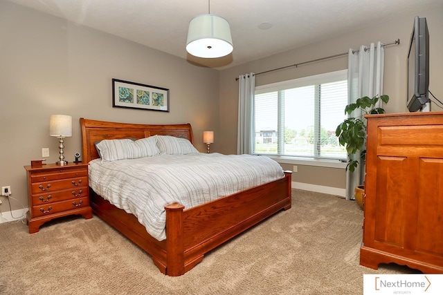 bedroom featuring light colored carpet and baseboards