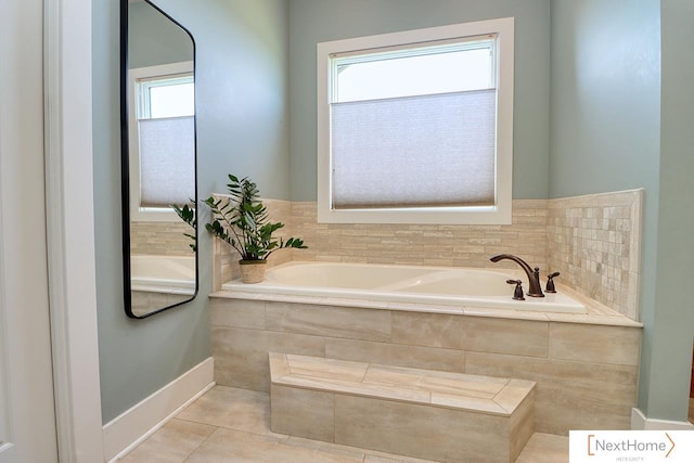 bathroom with a wealth of natural light, tile patterned flooring, and a bath