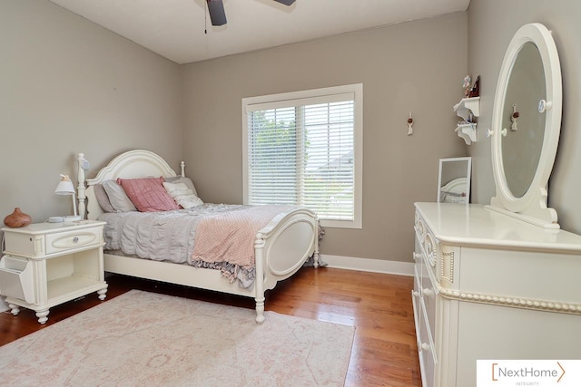 bedroom with a ceiling fan, baseboards, and wood finished floors