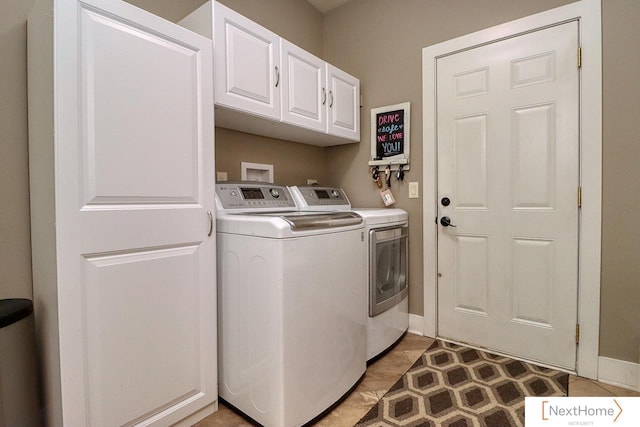 laundry area with washing machine and dryer, cabinet space, and baseboards