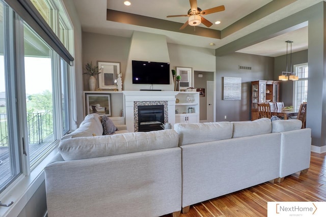 living area featuring visible vents, plenty of natural light, and wood finished floors