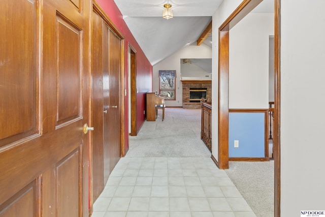 hallway with light carpet, lofted ceiling with beams, and light tile patterned flooring