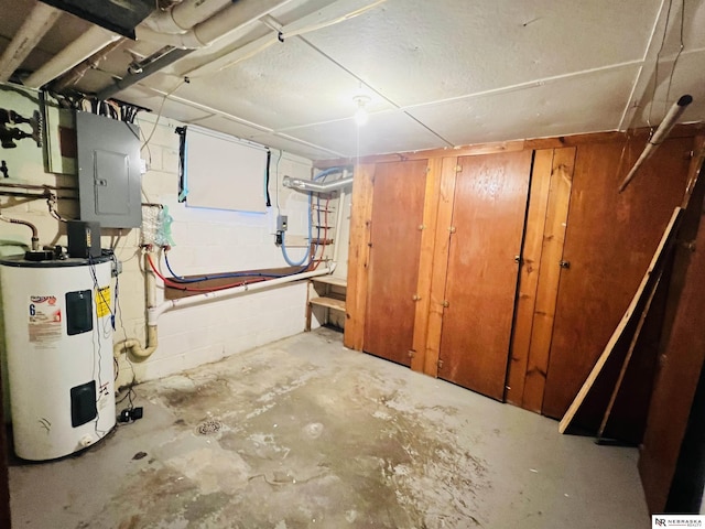 unfinished basement featuring concrete block wall, electric panel, and electric water heater